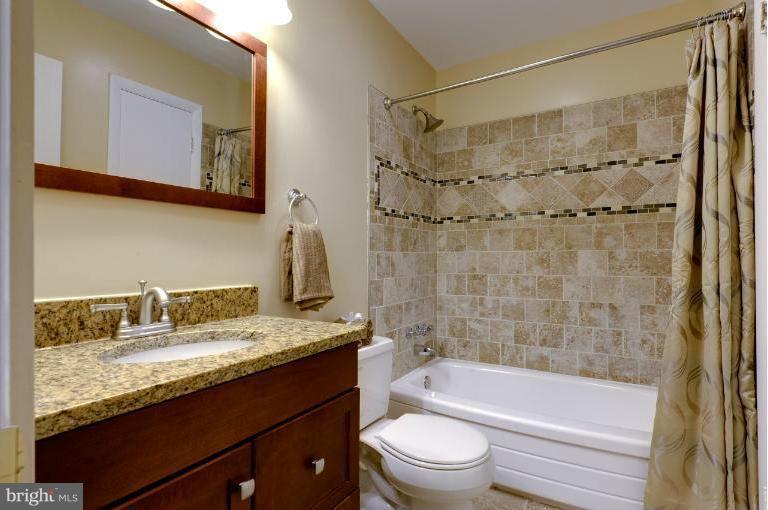 4748 Byron Road Windsor Mill, MD 21244 - Photo 4 of 27 a bathroom with a granite countertop sink a mirror a bathtub and shower