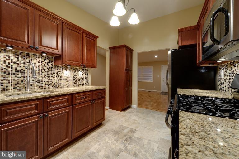 4748 Byron Road Windsor Mill, MD 21244 - Photo 6 of 27 a kitchen with stainless steel appliances granite countertop a stove and a refrigerator