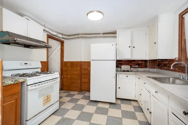a kitchen with a stove a sink and a refrigerator