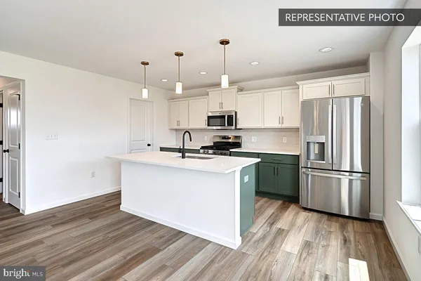 a kitchen with a refrigerator sink and cabinets