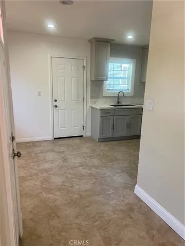 a view of an empty room with window and cabinet