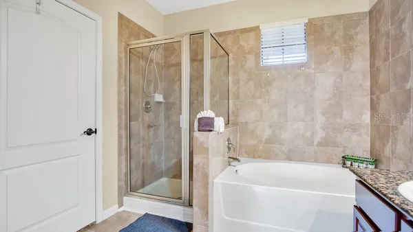 a bathroom with a tub shower and sink