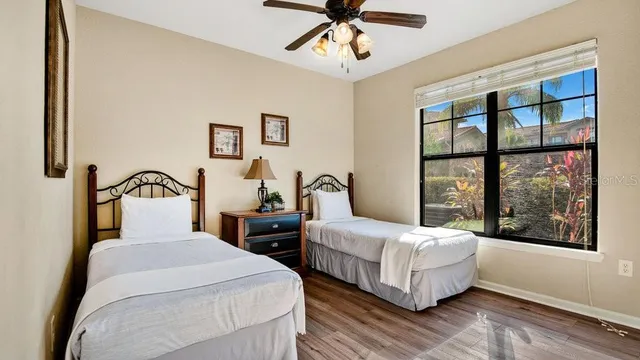 a bedroom with two beds and a large window