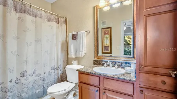 a bathroom with a granite countertop sink toilet and shower