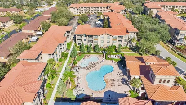 an aerial view of a house with swimming pool and outdoor seating