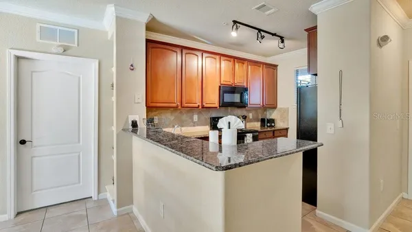 a kitchen with stainless steel appliances granite countertop a refrigerator and a sink