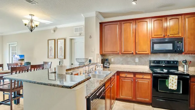 a kitchen with stainless steel appliances granite countertop a stove a sink and a microwave