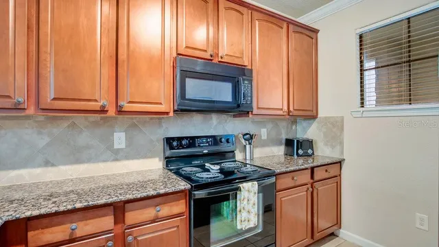 a kitchen with stainless steel appliances granite countertop cabinets and a stove top oven