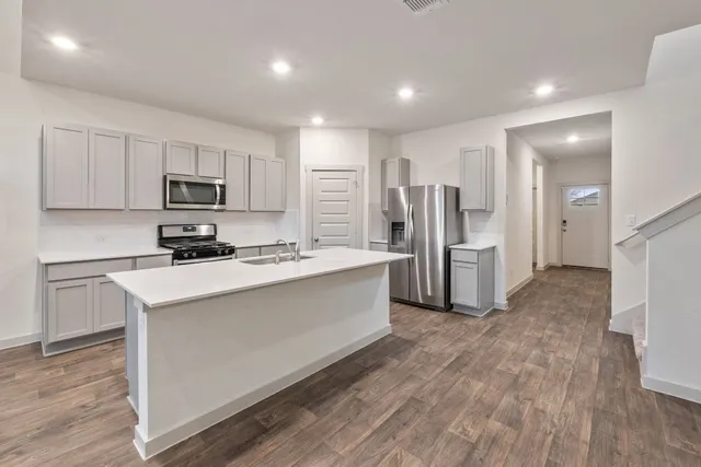 a kitchen with stainless steel appliances a refrigerator and a stove top oven