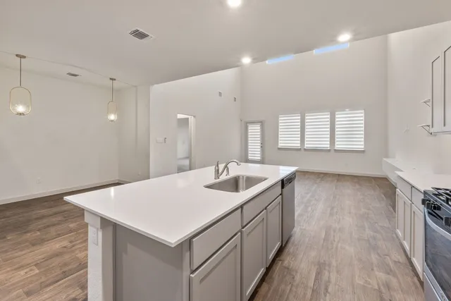 a kitchen with a sink and wooden floor
