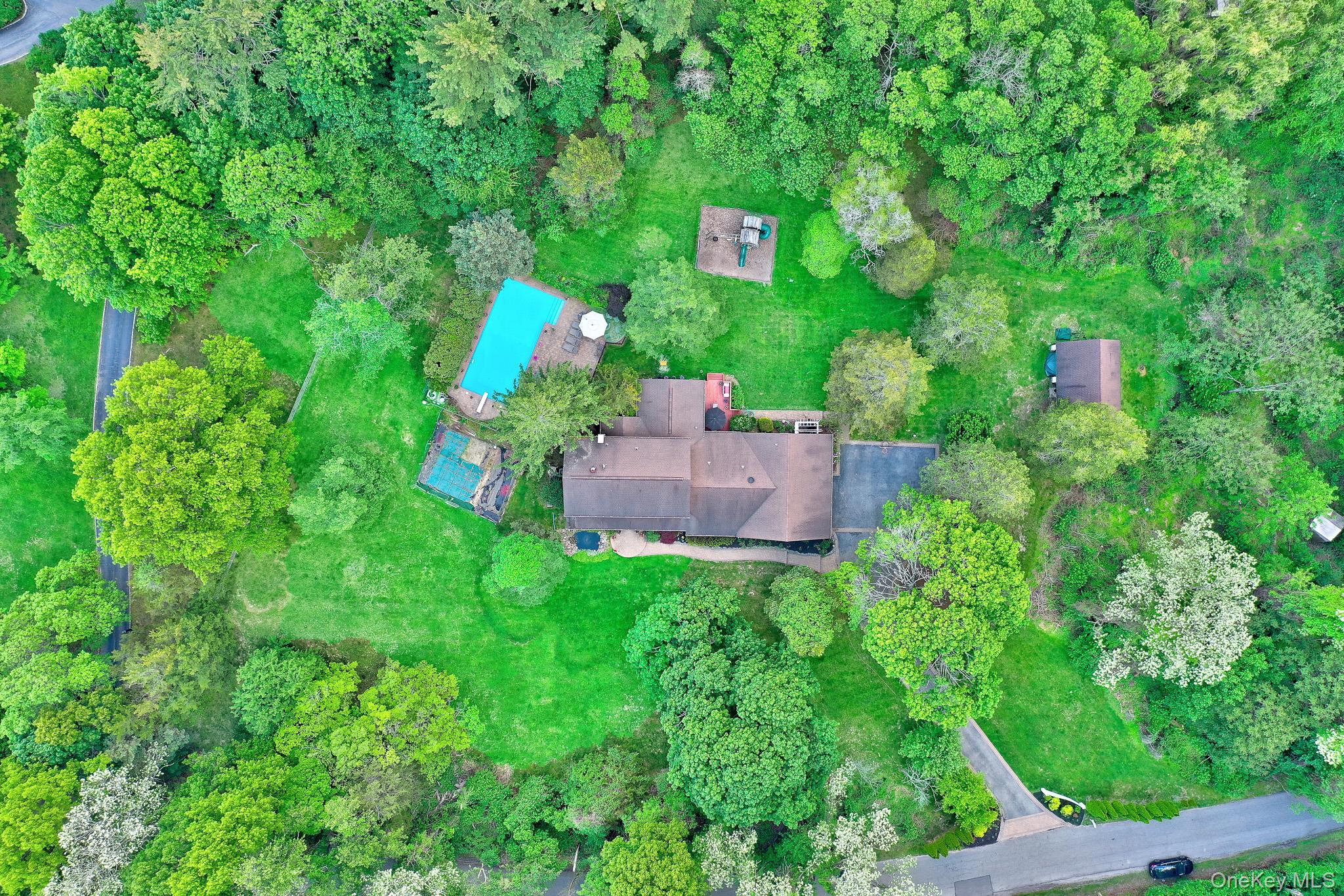 15 Stillwater Road Nissequogue, NY 11780 - Photo 37 of 43 Expansive property featuring a main residence, a detached auxiliary building, a rectangular swimming pool, and a hardscaped patio area