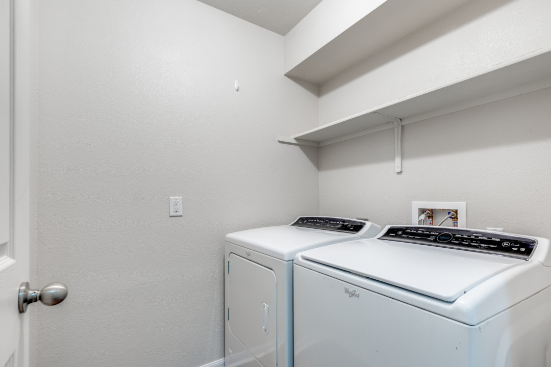13708 Sierra Wind Lane Elgin, TX 78621 - Photo 10 of 19 Laundry room with independent washer and dryer and shelving