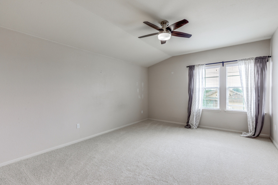 13708 Sierra Wind Lane Elgin, TX 78621 - Photo 12 of 19 Empty room with carpet, vaulted ceiling, and ceiling fan