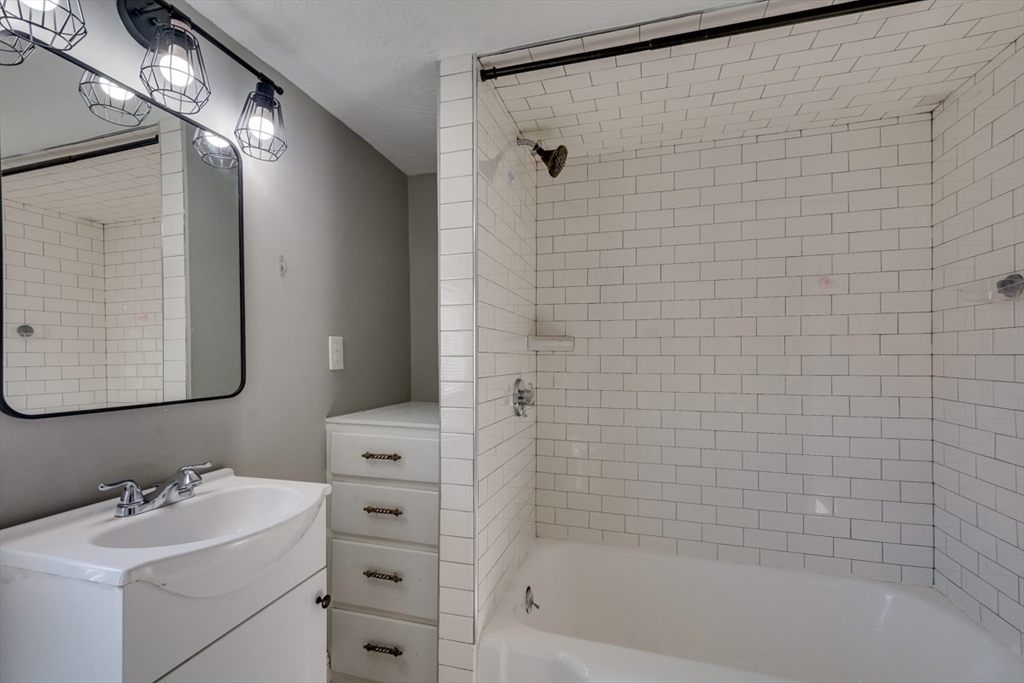 96 Pleasant Street, Unit 96 Ashland, MA 01721 - Photo 16 of 20 a bathroom with a sink mirror and shower