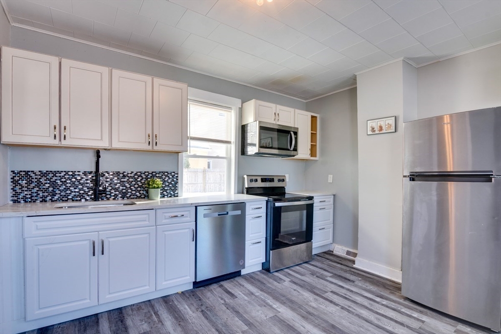 96 Pleasant Street, Unit 96 Ashland, MA 01721 - Photo 3 of 20 a kitchen with granite countertop a refrigerator stove and sink