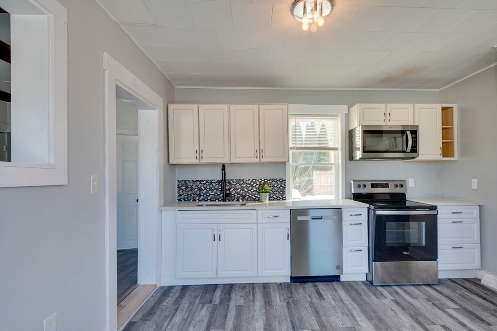 96 Pleasant Street, Unit 96 Ashland, MA 01721 - Photo 4 of 20 a kitchen with stainless steel appliances granite countertop a stove top oven a sink dishwasher and a refrigerator with wooden floor