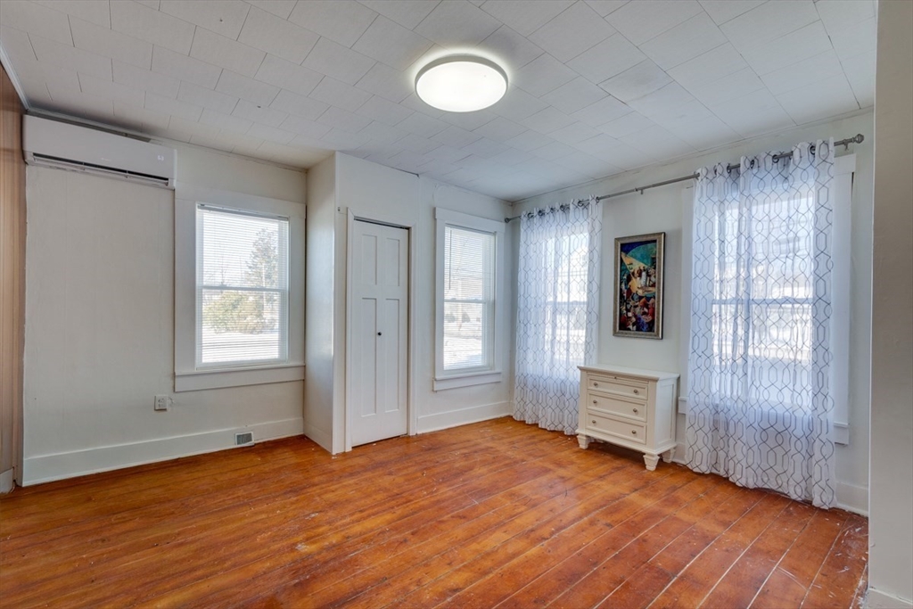 96 Pleasant Street, Unit 96 Ashland, MA 01721 - Photo 9 of 20 an empty room with wooden floor and windows