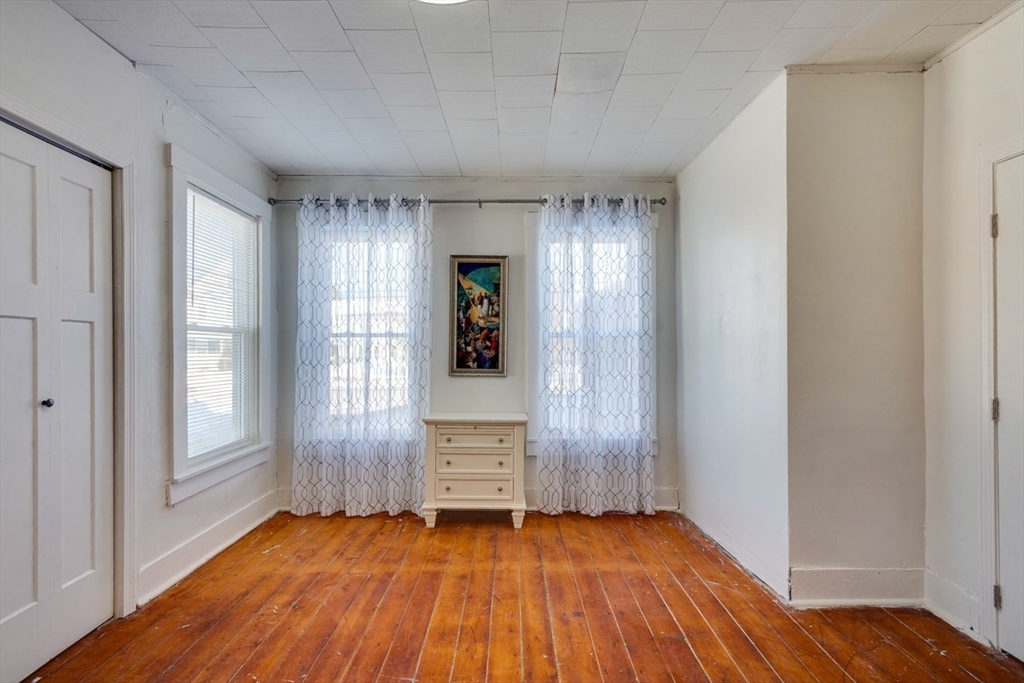 96 Pleasant Street, Unit 96 Ashland, MA 01721 - Photo 10 of 20 an empty room with wooden floor and windows