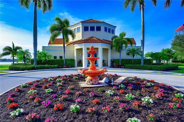 a front view of a house with a yard and fountain