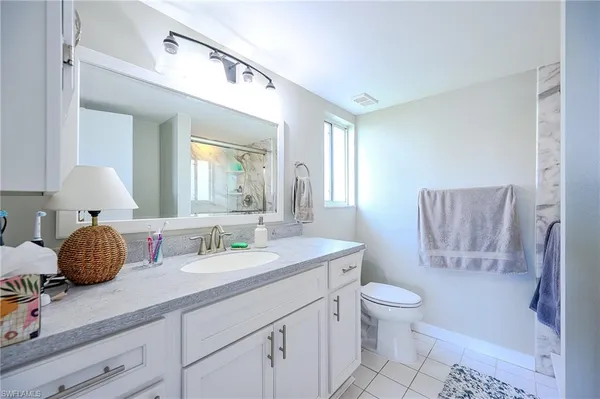a bathroom with a granite countertop toilet sink and mirror