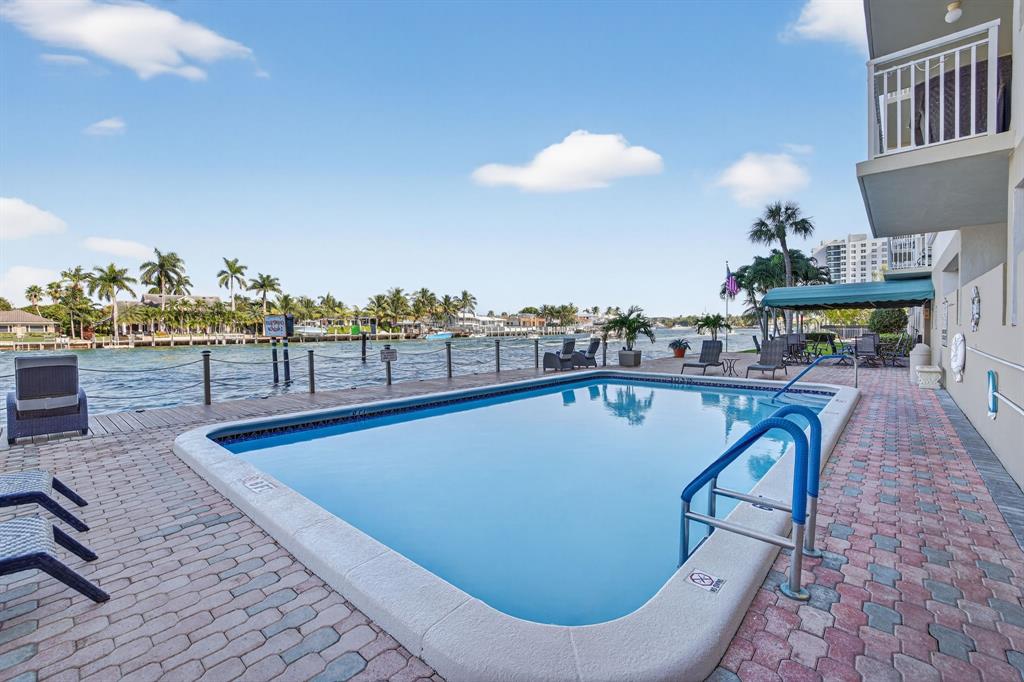 2611 North Riverside Drive, Unit 304 Pompano Beach, FL 33062 - Photo 44 of 61 a view of a swimming pool with a lounge chairs