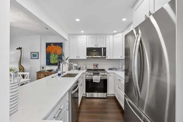 a kitchen with stainless steel appliances a refrigerator sink and microwave