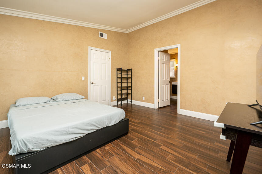 13680 Bear Valley Road Moorpark, CA 93021 - Photo 20 of 50 a bedroom with a bed and wooden floor