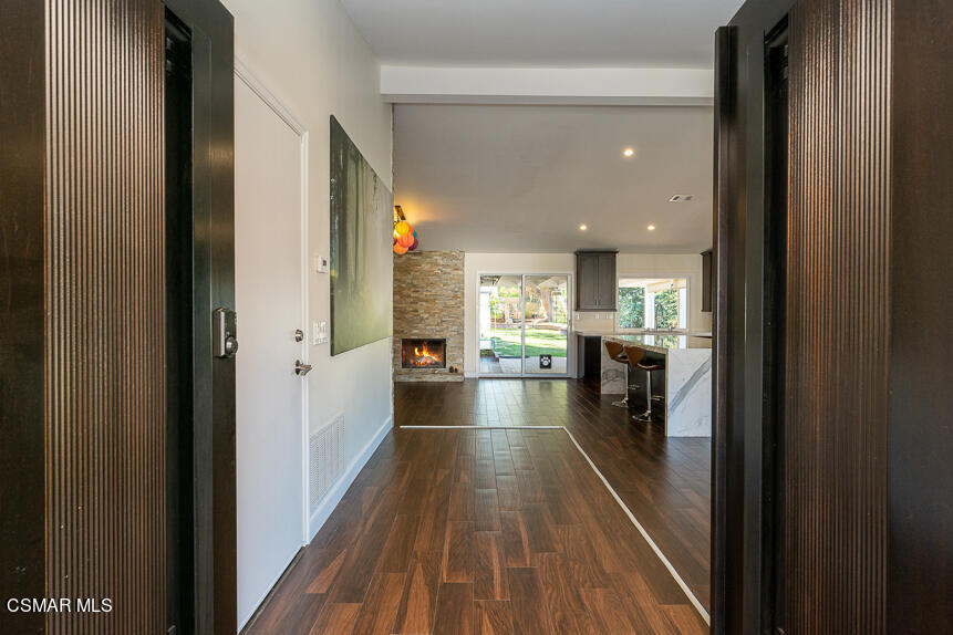 13680 Bear Valley Road Moorpark, CA 93021 - Photo 4 of 50 a view of a hallway with wooden floor and a living room