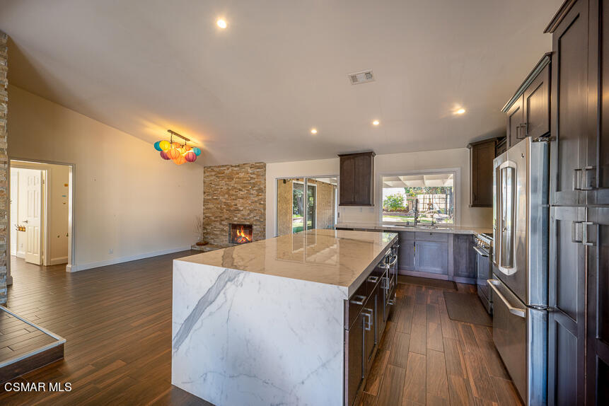 13680 Bear Valley Road Moorpark, CA 93021 - Photo 10 of 50 a kitchen with stainless steel appliances granite countertop a refrigerator a sink dishwasher a oven and a dining table with wooden floor