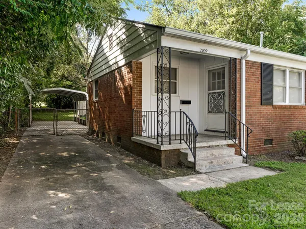 a view of a house with backyard and a tree