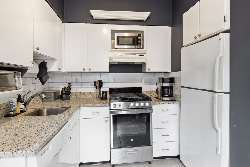 120 Sutherland Road, Unit 7 Boston, MA 02135 - Photo 11 of 25 a kitchen with granite countertop a refrigerator stove and sink