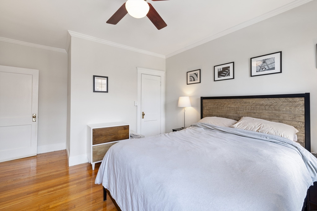 120 Sutherland Road, Unit 7 Boston, MA 02135 - Photo 18 of 25 a bedroom with a bed and wooden floor