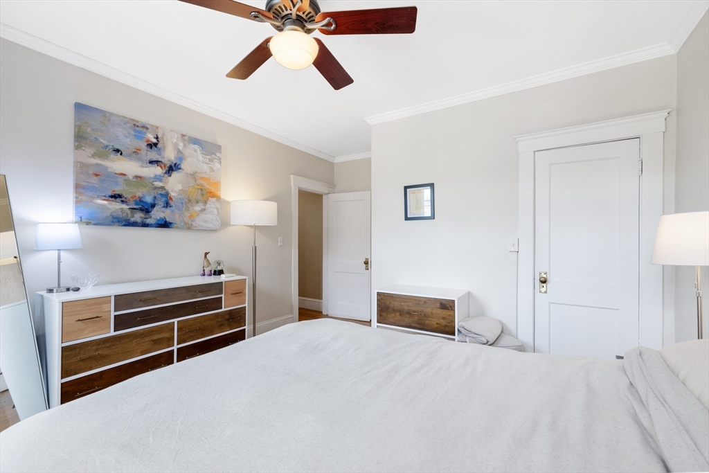 120 Sutherland Road, Unit 7 Boston, MA 02135 - Photo 19 of 25 a bedroom with a bed and a chandelier