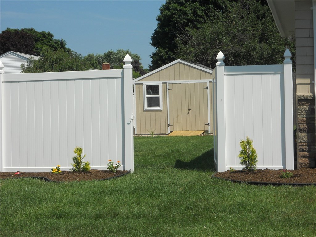 FRONT YARD VIEW OF FENCED REAR YARD, WITH 12 X 12 BARN YARD STYLE DOOR SHED, NEW DRIVE-IN RAMP, TO DRIVE IN YOUR RIDING LAWN MOWER. NICELY LANDSCAPED