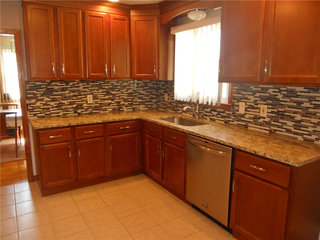 12 Lawrence Road North Providence, RI 02911 - Photo 22 of 40 NEW BACK SPLASH SURROUNDS YOUR NEW GRANITE COUNTER TOP, WITH DEEP DOUBLE STAINLESS SINK, AMPLE STORAGE IN 13 CABINET DOORS AND 4 WORKING DRAWERS, THIS VIEW INCLUDE OFF KITCHEN FORMAL DINING ROOM.