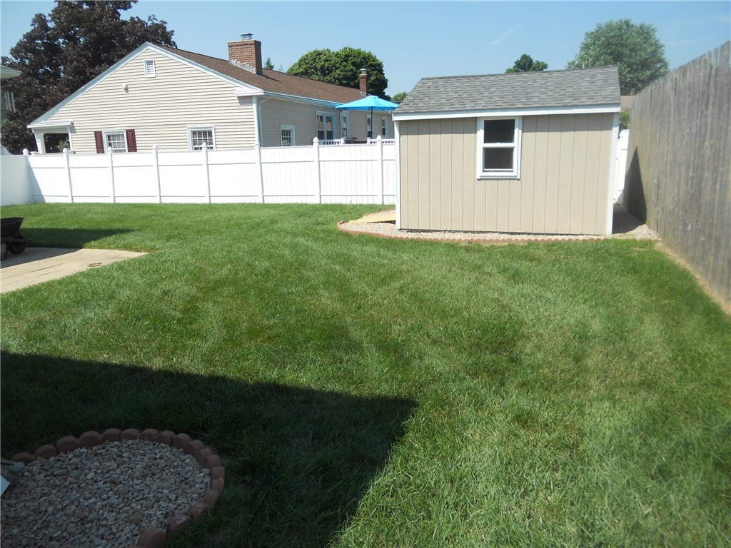 SIDE YARD VIEW OF REAR YARD FENCED AND NICELY LANDSCAPED, WITH NEW DRIVE RAMP FOR 12 X 12 DRIVE-IN SHED