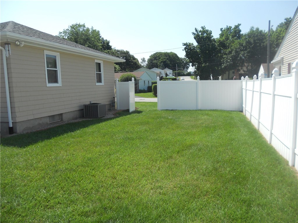 SIDE YARD VIEW, SHOWING A/C UNIT, GAS METER, AND LOCKING GATE.