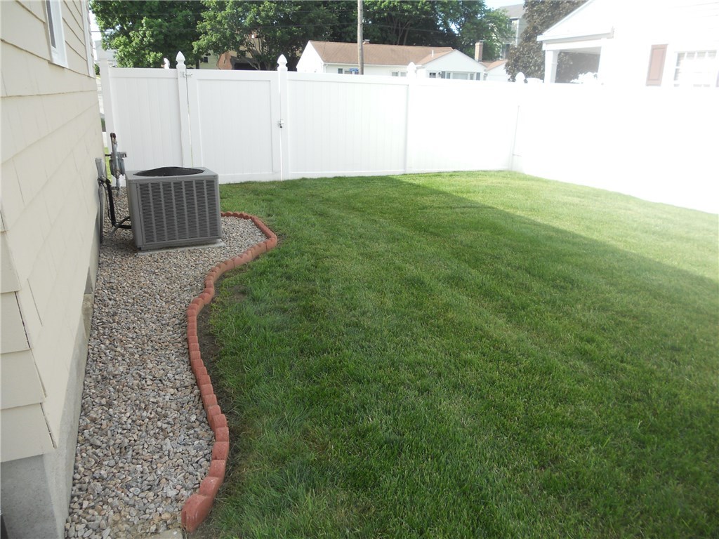 SIDE VIEW-PRIVATE REAR YARD, NICELY LANDSCAPED 2 LOCKING WIDE GATES ABLE TO DRIVE A RIDING LAWN MOWER THRU, HAS 12 X 12 NEWER SHED, AND PATIO WITH NEWER BULKHEAD,SHOWING A/C AND GAS METER