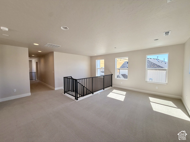 1595 West Canyon Rim Road, Unit 630 Lehi, UT 84048 - Photo 24 of 41 Open loft area featuring neutral-toned carpeting, multiple windows, recessed lighting, and a black wrought iron railing system