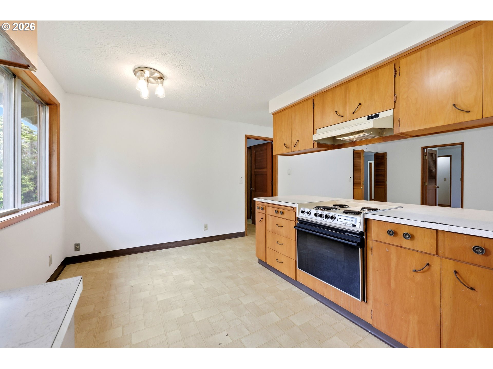 3003 Southeast 162nd Avenue Portland, OR 97236 - Photo 14 of 41 a kitchen with stainless steel appliances granite countertop a stove a sink and a refrigerator with wooden cabinets