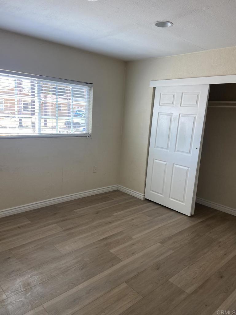 917 Broadview Street Spring Valley, CA 91977 - Photo 8 of 14 an empty room with wooden floor and windows