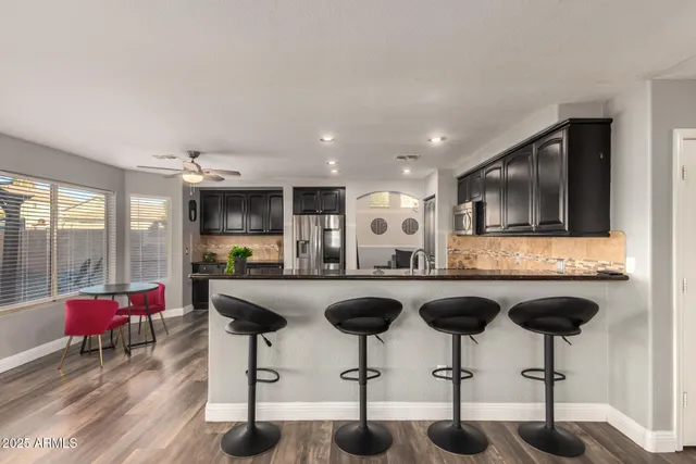 a living room with stainless steel appliances kitchen island granite countertop furniture and a flat screen tv