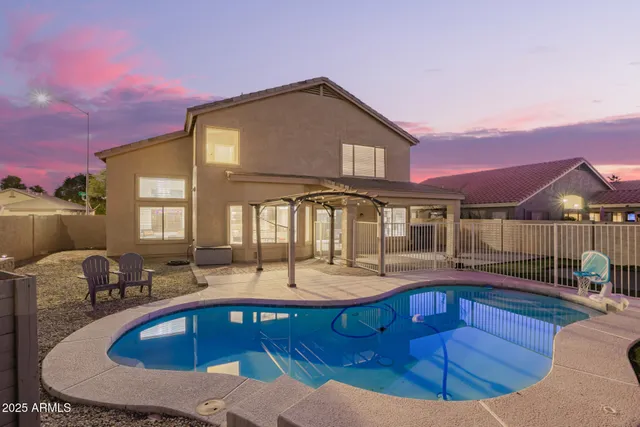 a front view of a house with swimming pool and yard