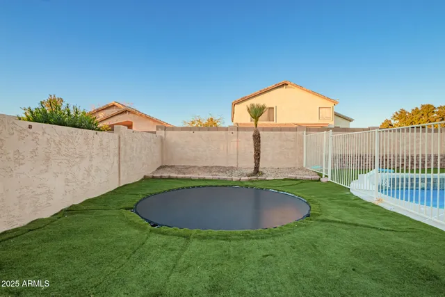a view of a backyard with swimming pool