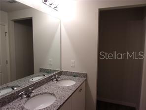 11357 Elgin Boulevard Spring Hill, FL 34608 - Photo 9 of 15 a bathroom with a granite countertop sink and a mirror