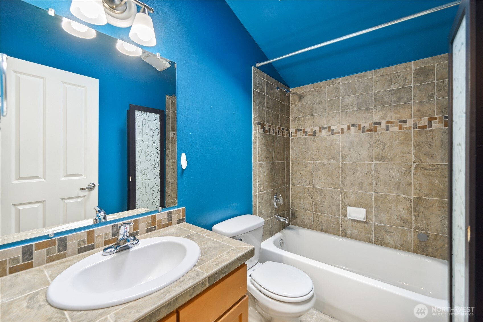 8403 8th Avenue Northwest, Unit B Seattle, WA 98117 - Photo 14 of 16 a bathroom with a sink a toilet a mirror a bathtub and shower