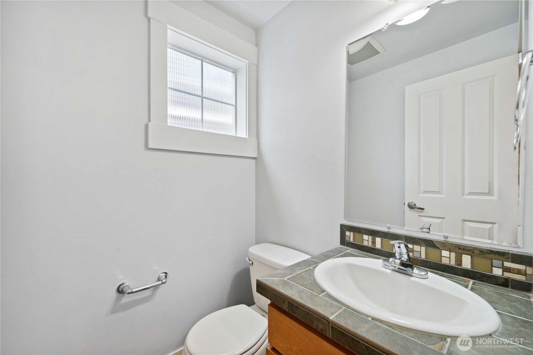 8403 8th Avenue Northwest, Unit B Seattle, WA 98117 - Photo 8 of 16 a bathroom with a granite countertop toilet sink and mirror