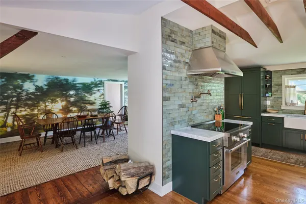 a kitchen with stainless steel appliances granite countertop a stove and a view of living room