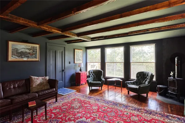 a living room with furniture floor to ceiling window and a flat screen tv
