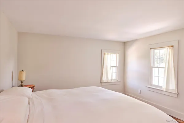 a bedroom with a bed and a window with a chair